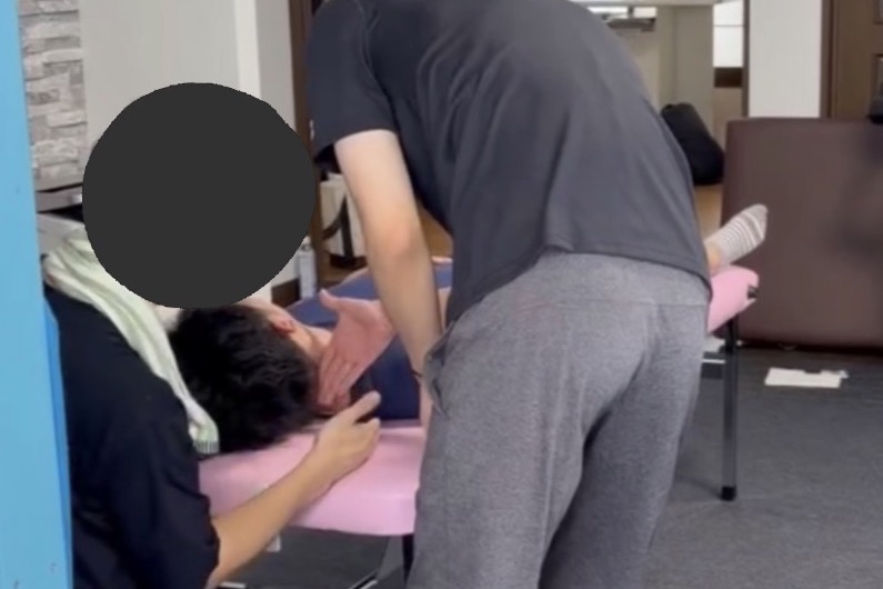 講師が受講生の手の位置と力加減を確認して修正する様子